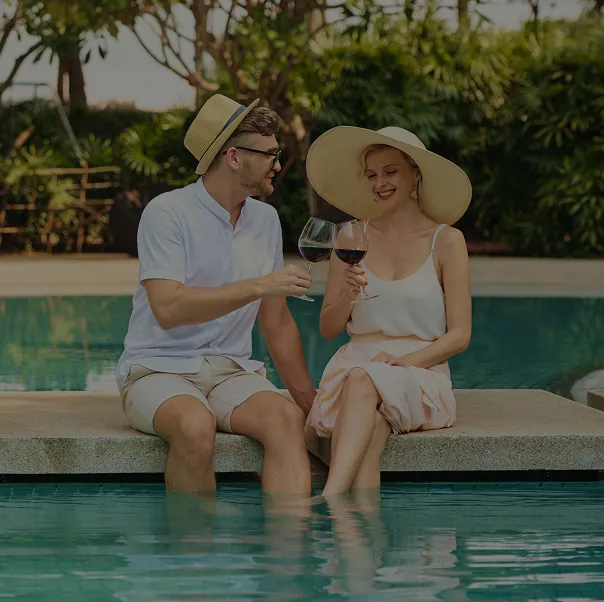 Pareja tomando vino en la piscina